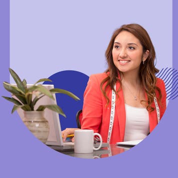 Young woman smiling and sitting next to a laptop