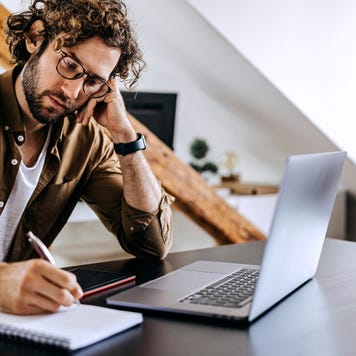Man resting his hand on his face while reviewing documents