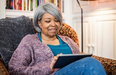 Senior woman using digital tablet in home environment