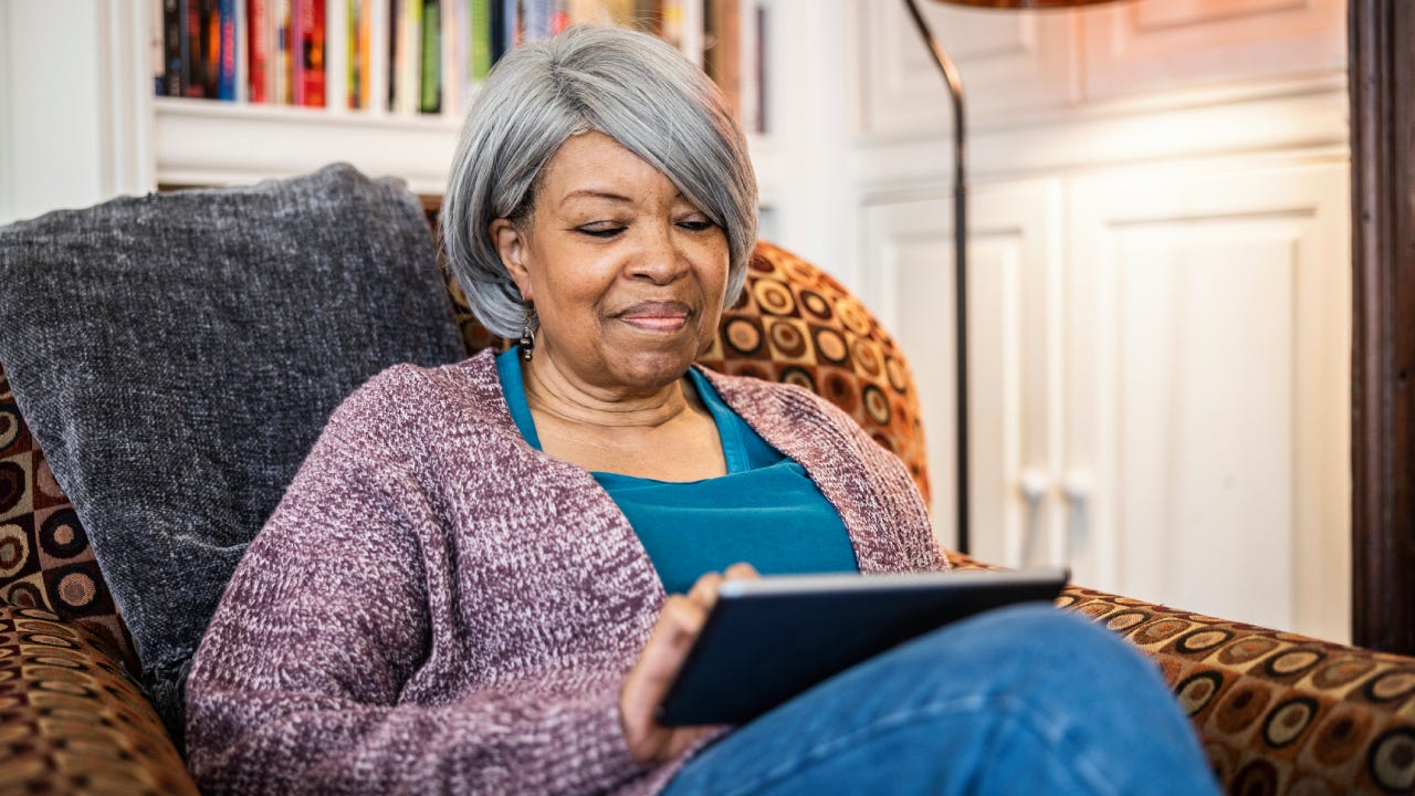 Senior woman using digital tablet in home environment