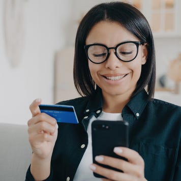 Young woman pays for purchases in online store using banking service