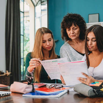 A mother and her daughters review their education cost paperwork.