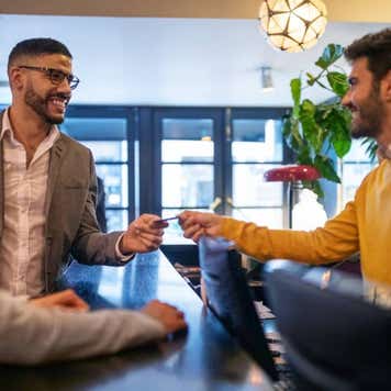 Businessman getting hotel room key card from reception