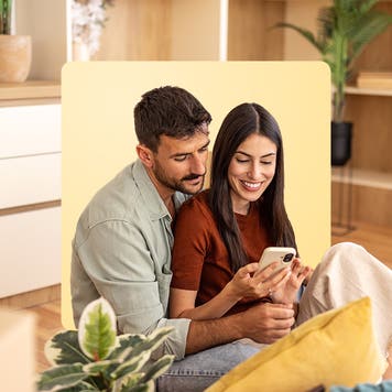 a male-female couple looking at home listings together on a cell phone