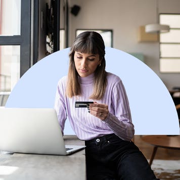 Design element including person holding credit card in front of a laptop