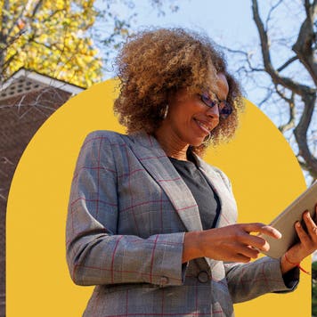 Realtor standing outside a home looking at paperwork