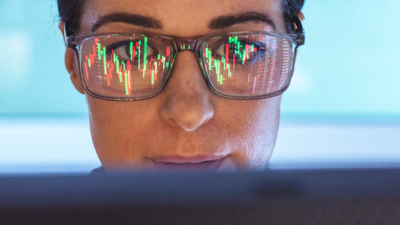 Stockbroker analyzing financial stock market with reflection on eyeglasses