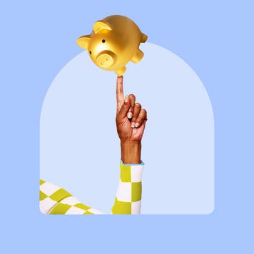 Holding up a golden piggy bank, balancing on one finger