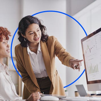 Co-workers discussing something on a computer screen