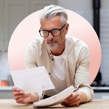mature man reading his policy while wearing glasses