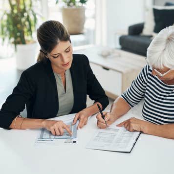female financial advisor meeting with an elderly female client reviewing her life insurance policy