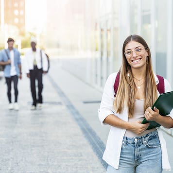 Blond college girl smiling, ready for classes at a university campus