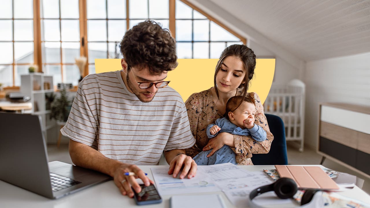 Young parents working with financial documents on the dining room table