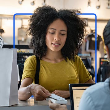 Woman paying for merchandise at store with credit card