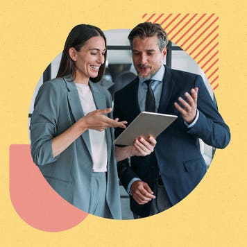 Two young professionals discussing something around a tablet computer