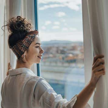 Woman looking out the window at scenic view below.