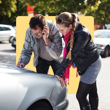 Drivers examining damage to car after an accident