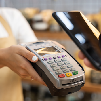 Customer making a contactless payment on a smartphone in the pottery shop