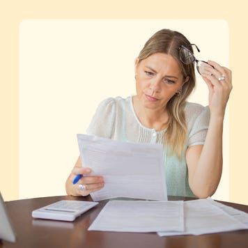 Woman appearing stressed when looking at financial documents