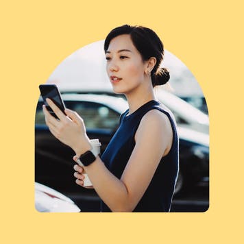 An east Asian woman looking at her phone while at a car lot. Image is on a yellow background.