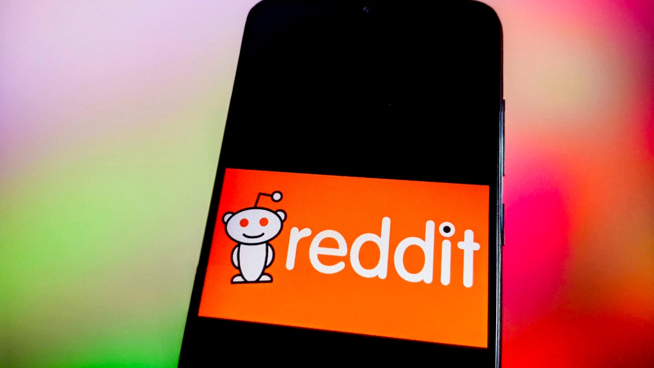 The Reddit logo appears on a phone screen