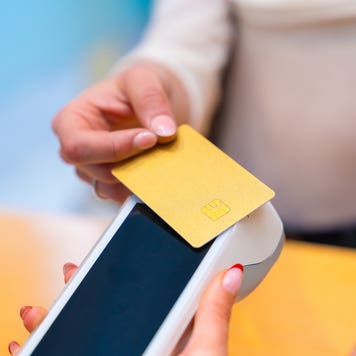 Close-up of a woman paying using credit card in a beautician clinic