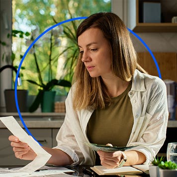 Person sitting at desk looking over bills