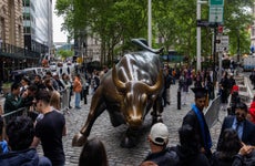 Visitors at the "Charging Bull" statue near the New York Stock Exchange (NYSE) in New York, US, on Thursday, May 16, 2024.