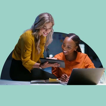 Two women look at an iPad.