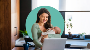 Woman workng and holding baby.