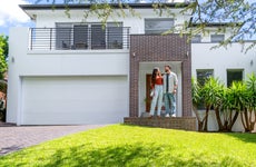 Couple standing proudly in front of their new home