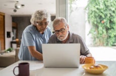 Senior couple talking about home finances and using the laptop at home