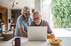 Senior couple talking about home finances and using the laptop at home