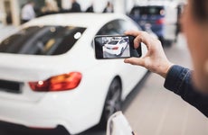 Person taking a picture of a car with their smartphone