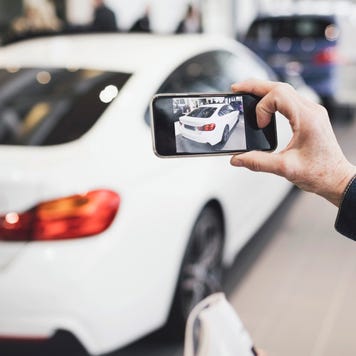 Person taking a picture of a car with their smartphone