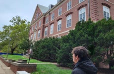 Young man looking out over a college campus