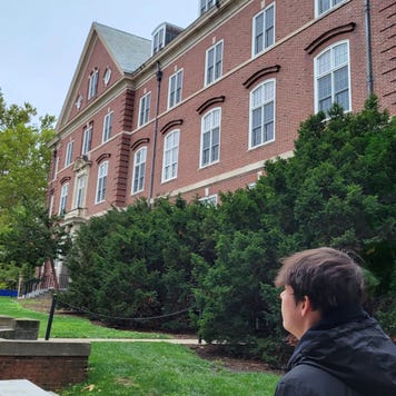 Young man looking out over a college campus