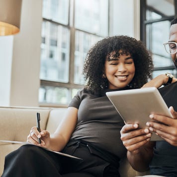 Two people on sofa looking at tablet