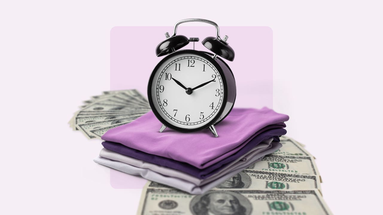Analog alarm clock on top of a pile of cash