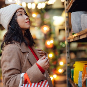 woman with shopping bags choosing gifts at Christmas market