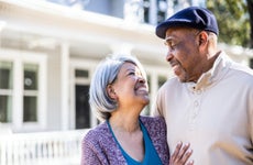 senior couple in front of suburban home
