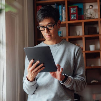 man banking online with digital tablet at home