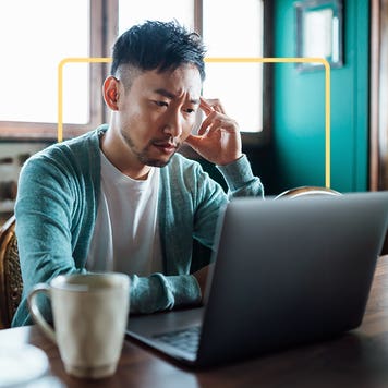 Man at laptop, deep in thought