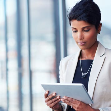 Shot of a young businesswoman using a digital tablet outside of an office