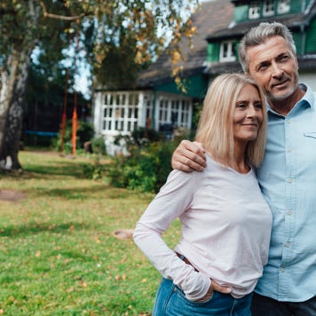 Smiling man with arm around woman at backyard