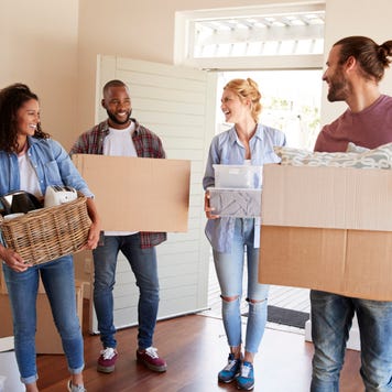 Friends carrying boxes into their new home