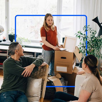 Millennial with moving box talking to parents in their house