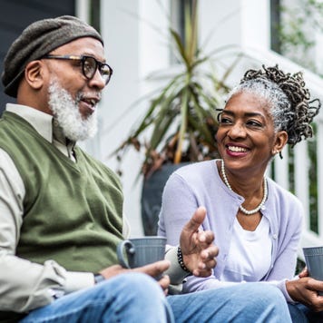 An older couple enjoying a hot beverage on their porch