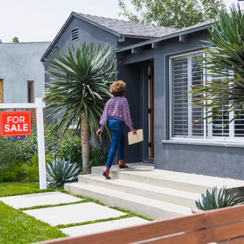real estate agent carrying document while walking into house