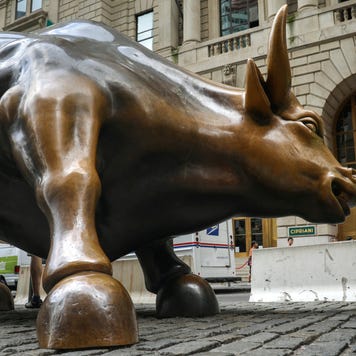 Tourists visit the Wall Street bull statue in the Financial District